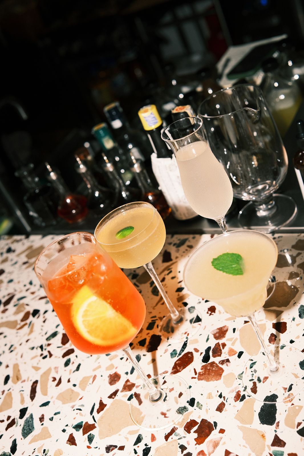 A lineup of cocktails on the terrazzo bar counter at Rembar