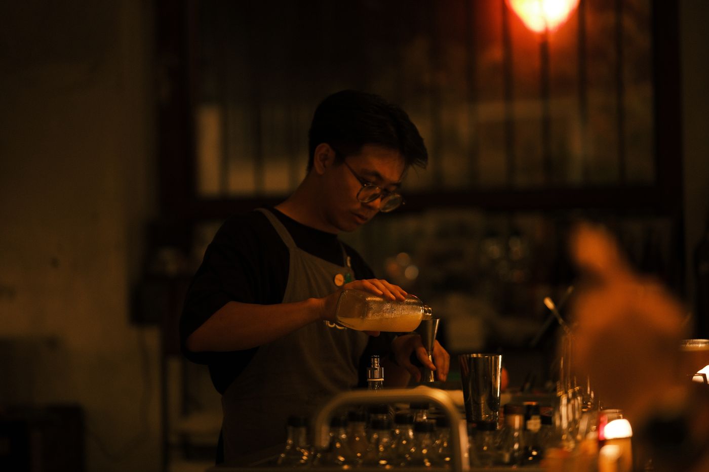 A bartender pouring a cocktail at Rembar
